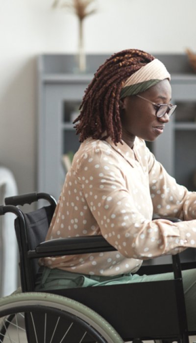 Mulher negra em cadeira de rodas trabalhando em um notebook